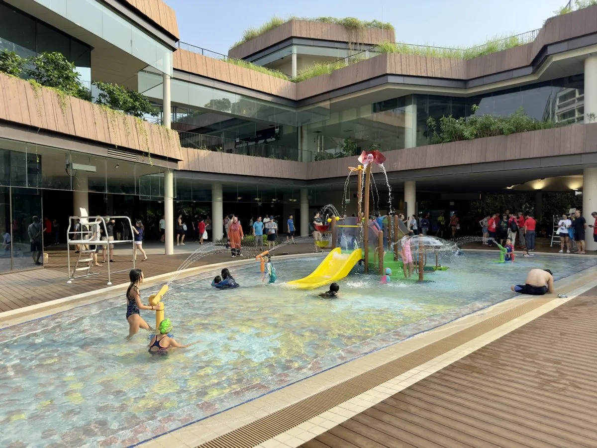 Outdoor kids water play area with yellow slide at Bukit Canberra Swimming Complex